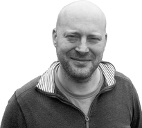 Image of technical director of pool lift company in black and white. The man is bald, relaxed looking, attractive and smiling with short beard.